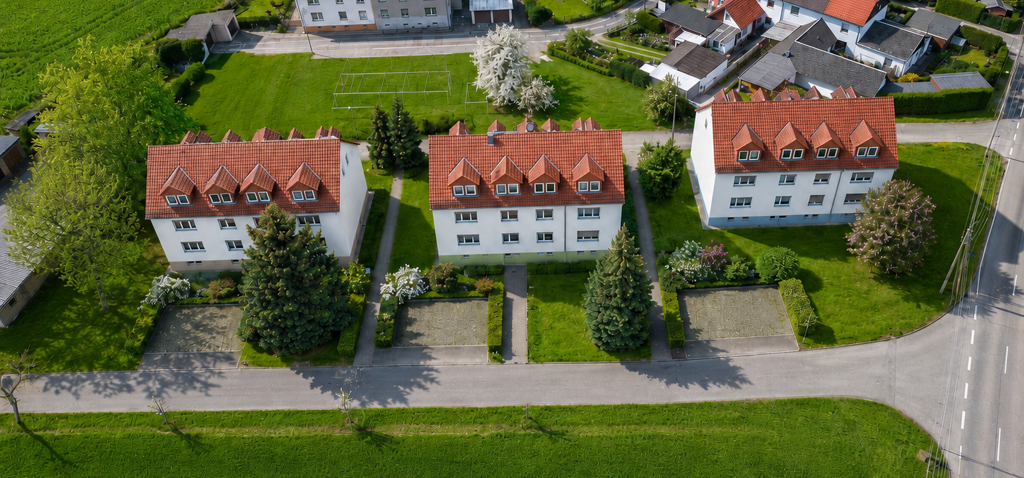 Moderne Wohnanlage mit Mehrfamilienhäusern und großzügigen Grünflächen in familienfreundlicher Lage – attraktiver Wohnraum und Immobilien im Leipziger Land.